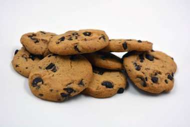 Beyaz arka planda çikolata parçalı büyük, lezzetli bir kurabiye..