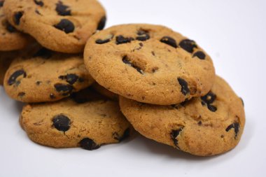 Beyaz arka planda çikolata parçalı büyük, lezzetli bir kurabiye..