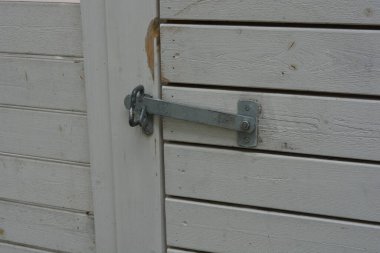 İnşaat, eskrim, bölgeyi komşulardan ve kötü niyetlilerden koruma. Büyük ahşap bir kapısı ve metal bir sapı olan doğal çitten yapılmış parlak, beyaz bir çit..