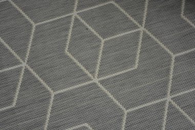 Things are objects of everyday life, part of the interior. New woven gray carpet with light, white chaotic lines and unusual graphic pattern.