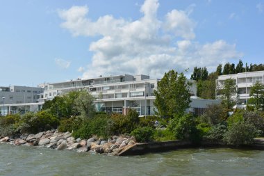 Güzel, parlak doğa, yeşil köknar ağaçları, uzun çam ağaçları, ağaçlar ve güzel beyaz evleri olan tepelik bir manzara. Finlandiya 'nın Espoo şehrinde Finlandiya kıyısında yeni güzel evler bulunmaktadır..