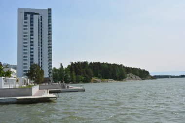 Güzel, parlak doğa, yeşil köknar ağaçları, uzun çam ağaçları, ağaçlar ve güzel beyaz evleri olan tepelik bir manzara. Finlandiya 'nın Espoo şehrinde Finlandiya kıyısında yeni güzel evler bulunmaktadır..