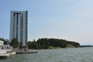 Güzel, parlak doğa, yeşil köknar ağaçları, uzun çam ağaçları, ağaçlar ve güzel beyaz evleri olan tepelik bir manzara. Finlandiya 'nın Espoo şehrinde Finlandiya kıyısında yeni güzel evler bulunmaktadır..