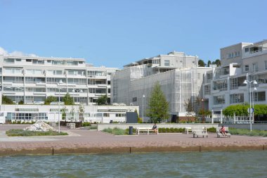 Güzel, parlak doğa, yeşil köknar ağaçları, uzun çam ağaçları, ağaçlar ve güzel beyaz evleri olan tepelik bir manzara. Finlandiya 'nın Espoo şehrinde Finlandiya kıyısında yeni güzel evler bulunmaktadır..