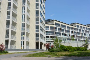 Daireler, evler, deniz kenarında bulunan ve Finlandiya 'nın Espoo şehrindeki güneş ışınlarıyla aydınlatılan gayrimenkuller. Büyük cam balkonlu yeni güzel beyaz evler yüksek yeşil ağaçlar, köknarlar ve çamlar arasında yer alıyor..