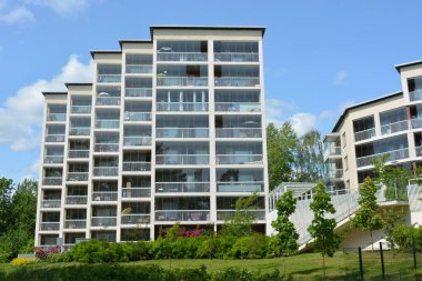 Daireler, evler, deniz kenarında bulunan ve Finlandiya 'nın Espoo şehrindeki güneş ışınlarıyla aydınlatılan gayrimenkuller. Büyük cam balkonlu yeni güzel beyaz evler yüksek yeşil ağaçlar, köknarlar ve çamlar arasında yer alıyor..