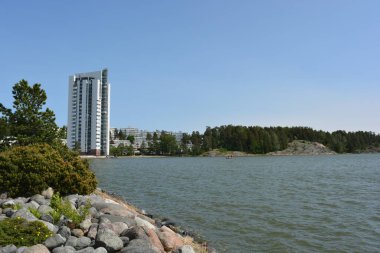 Güzel, parlak doğa, yeşil köknar ağaçları, uzun çam ağaçları, ağaçlar ve güzel beyaz evleri olan tepelik bir manzara. Finlandiya 'nın Espoo şehrinde Finlandiya kıyısında yeni güzel evler bulunmaktadır..