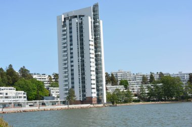 Güzel, parlak doğa, yeşil köknar ağaçları, uzun çam ağaçları, ağaçlar ve güzel beyaz evleri olan tepelik bir manzara. Finlandiya 'nın Espoo şehrinde Finlandiya kıyısında yeni güzel evler bulunmaktadır..