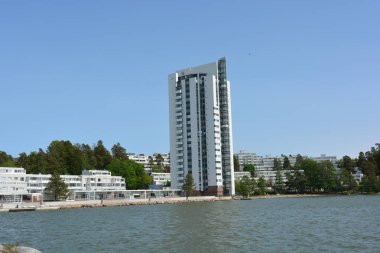 Güzel, parlak doğa, yeşil köknar ağaçları, uzun çam ağaçları, ağaçlar ve güzel beyaz evleri olan tepelik bir manzara. Finlandiya 'nın Espoo şehrinde Finlandiya kıyısında yeni güzel evler bulunmaktadır..