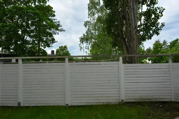 İnşaat, eskrim, bölgeyi komşulardan ve kötü niyetlilerden koruma. Büyük ahşap bir kapısı ve metal bir sapı olan doğal çitten yapılmış parlak, beyaz bir çit..