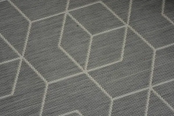 Things are objects of everyday life, part of the interior. New woven gray carpet with light, white chaotic lines and unusual graphic pattern.