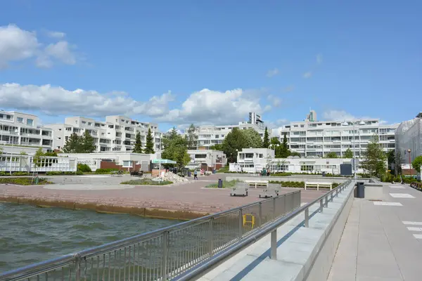 Bright nature, hilly landscape with green fir trees, tall spruce trees, trees and beautiful white houses. Real estate, new beautiful houses are along the Finnish coast in Espoo city, Finland.