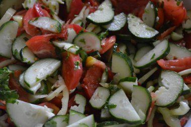 Düzgün, sağlıklı beslenme, sağlıklı sebzeler, salata büyük metal bir kasede bulunur. Dilimlenmiş kırmızı domates, sarı ve kırmızı dolma biber, beyaz soğan, yeşil salatalık ve ekşi sarımsak sosu..