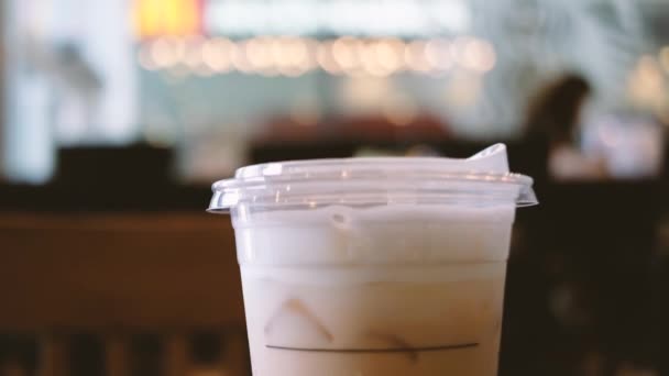 背景模糊的塑料杯冰镇咖啡的特写 — 图库视频影像