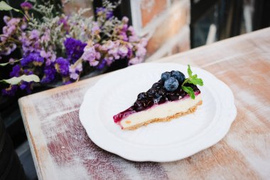 Tahta masada bir parça yabanmersinli cheesecake..