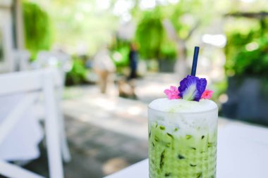 Kafede yeşil çay, arka planda bulanık buzlu yeşil çay. Yeşil çay latte..