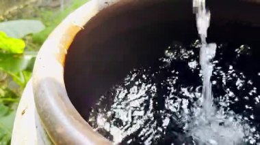 Büyük toprak kavanozuna su dök, kilden yapılmış su kasesi ya da kavanozu kullan.