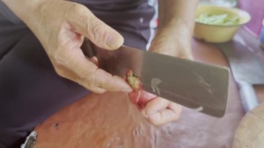 Asyalı aşçı Tayland mutfağında geleneksel taşra tarzında yemek pişiriyor. Tayland omleti pişirmek için taze soğan ya da soğan soymak için bıçakla hazırlanıyor.