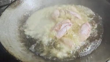Asyalı aşçı Tayland mutfağında geleneksel taşra usulü yemek pişiriyor. Sıcak tavuklarda pişen köpüklü yağla Tayland yemeği pişiriyor. Cildinde çıtır çıtır.