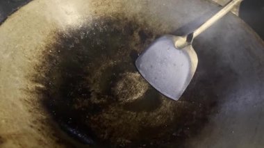 Asyalı aşçı Tayland mutfağında geleneksel köy usulü yemek pişiriyor. Tayland usulü yeşil köri ezmesi pişiriyor. Geleneksel tavada kızartılıyor.