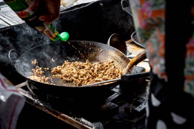 Bangkok Tayland 'daki Tayland sokak gıda pazarında ya da restoranda satılık domuz kızartması ya da biftek ve fesleğenle kaplı pirinç.