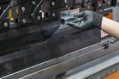 Hidrolik fren bükme makinesiyle çalışan beceri operatörü. Yetenek operatörünün kullandığı levha metal çalışması.