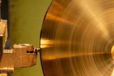 Closeup scene the lathe machine finish cut the brass parts by lathe tools. The metalworking process by turning machine.