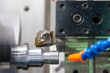 CNC torna makinesi metal çivi parçalarının sonunda iplik kesiyor. CNC dönüşüm makinesinin yüksek teknolojili metal işlemesi .