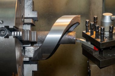 Torna makinesi, torna tezgahlarıyla dökme demir parçaları kesiyordu. Makineyi döndürerek metal işleme süreci.