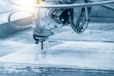 Çok eksenli yıpratıcı su jeti kesme makinesinin alüminyum plakayı kestiği yakın çekim sahnesi. CNC makinesiyle çalışan yüksek teknoloji levha metali.
