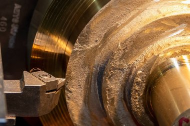 Closeup scene the lathe machine finish cut the brass parts by lathe tools. The metalworking process by turning machine.