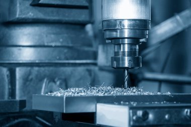 The drilling process on NC milling machine with coolant method. The metal working concept on the milling machine.