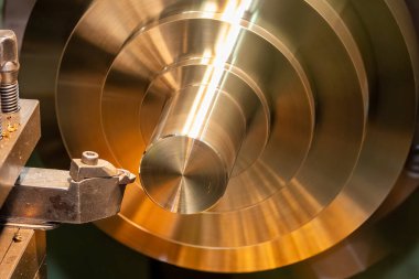 Closeup scene the lathe machine finish cut the brass parts by lathe tools. The metalworking process by turning machine.