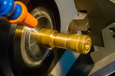 The  CNC lathe machine slot cutting the brass shaft parts. The hi-technology metal working processing by CNC turning machine .