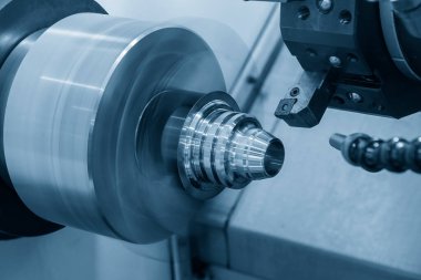 CNC torna makinesi metal koni şeklindeki parçaları kesiyor. CNC dönüşüm makinesinin yüksek teknolojili metal işlemesi .
