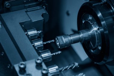 The  multi tasking CNC lathe machine  drilling the brass shaft parts. The hi-technology metal working processing by CNC turning machine .