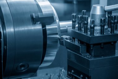 Yakından bakınca torna makinesi metal parçaları kesmiş. Makineyi döndürerek metal işleme süreci.