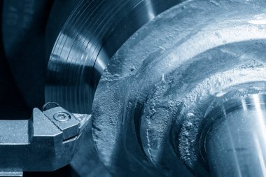 Yakından bakınca torna makinesi metal parçaları kesmiş. Makineyi döndürerek metal işleme süreci.