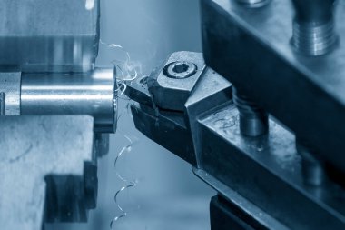 Yakından bakınca torna makinesi metal parçaları kesmiş. Makineyi döndürerek metal işleme süreci.