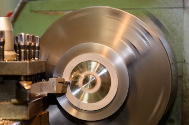 The lathe machine finish cut the metal parts by lathe tools. The metalworking process by turning machine.