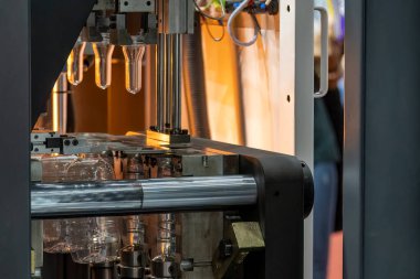 Küf makinesiyle içme suyu üretme işlemi. Plastik şişe üfleme makinesi operasyonu..