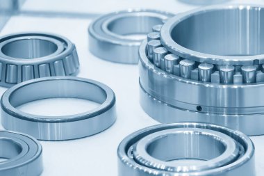 The cylindrical rolling bearing parts in light blue scene. The heavy mechanical part manufacturing concept.