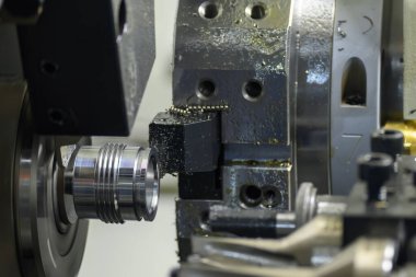 Çoklu görev yapan CNC torna makinesi İsviçre tipi iplik metal boru parçalarını kesiyor. CNC dönüşüm makinesiyle çalışan yüksek teknoloji metali.