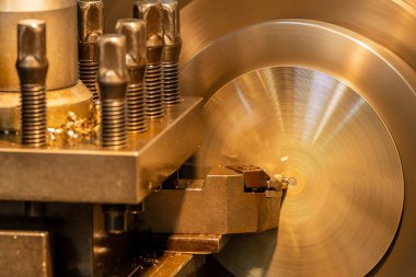 Closeup scene the lathe machine finish cut the brass parts by lathe tools. The metalworking process by turning machine.