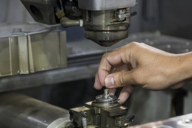 Operatör, EDM makinesini kurarken yakın çekim sahnesi. Zar atma işlemi CNC programı tarafından kablo kesme makine kontrolü ile kesme işlemi.