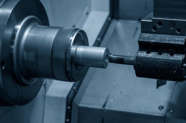 The  CNC lathe machine boring  cutting the metal shaft parts. The hi-technology metal working processing by CNC turning machine .