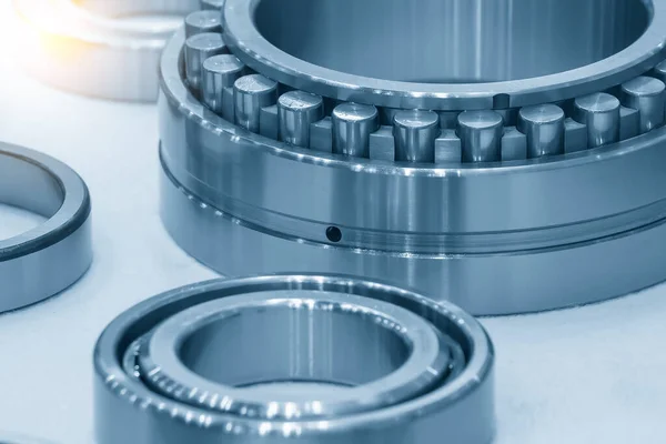 The cylindrical rolling bearing parts in light blue scene. The heavy mechanical part manufacturing concept.