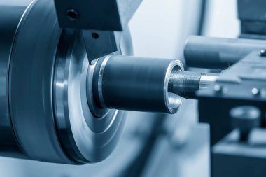 The  CNC lathe machine boring  cutting the metal shaft parts. The hi-technology metal working processing by CNC turning machine .