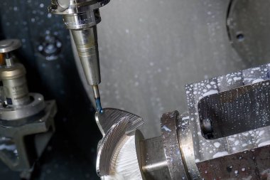 Close up the 5 axis machining center cutting the boat propeller parts  parts with taper ball end mill tool. The hi-precision parts  manufacturing process by multi-axis CNC milling machine.