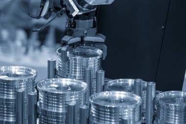 CNC torna makinesinin metal parçalarını tutan otomatik robot kolu. Dönüşüm makinesinde robotik sistem tarafından yüksek teknoloji materyal işleme süreci. 